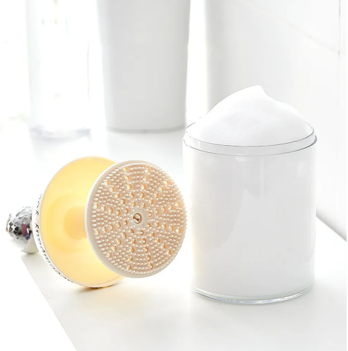 Cosmetic foaming agent with massage brush